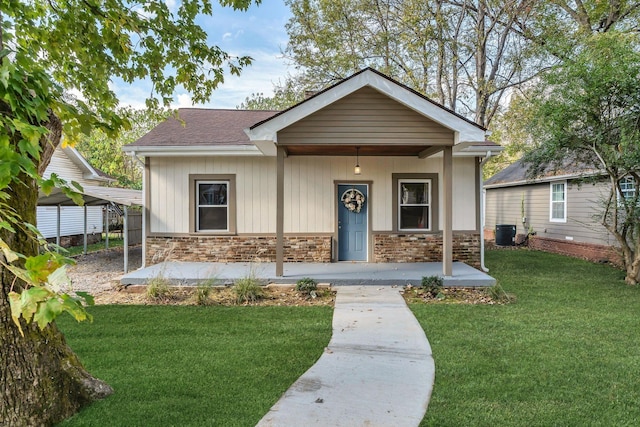 view of front of property featuring covered porch, central air condition unit, and a front lawn