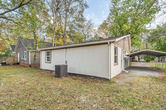 view of side of property with a carport, a lawn, and central AC unit