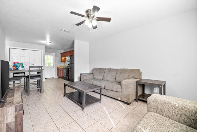 tiled living room with ceiling fan