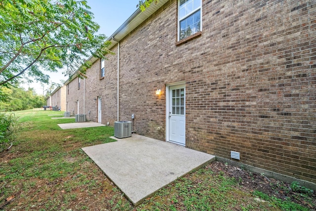 rear view of house featuring a lawn, a patio, and central AC