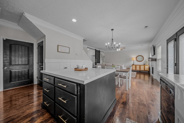 kitchen with crown molding, a barn door, decorative light fixtures, black dishwasher, and a kitchen island