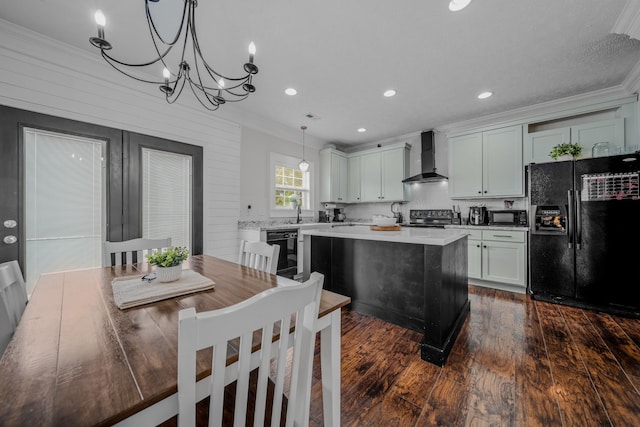 kitchen with wall chimney exhaust hood, dark wood-type flooring, black appliances, a center island, and hanging light fixtures