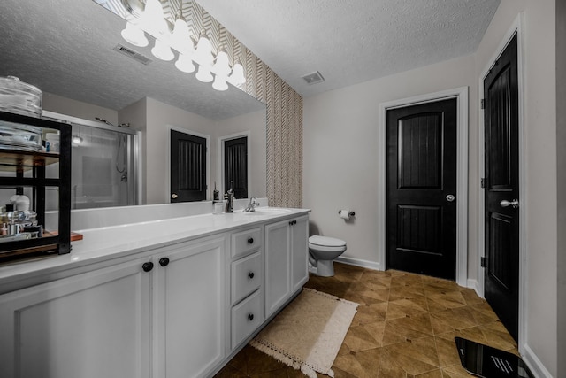 bathroom featuring vanity, tile patterned floors, toilet, a textured ceiling, and an enclosed shower