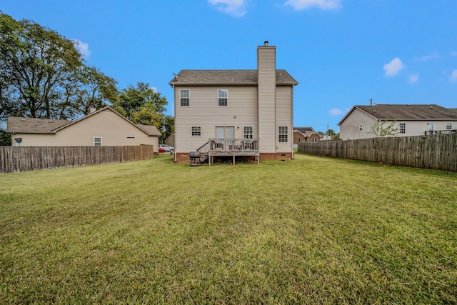 back of property with a deck and a yard