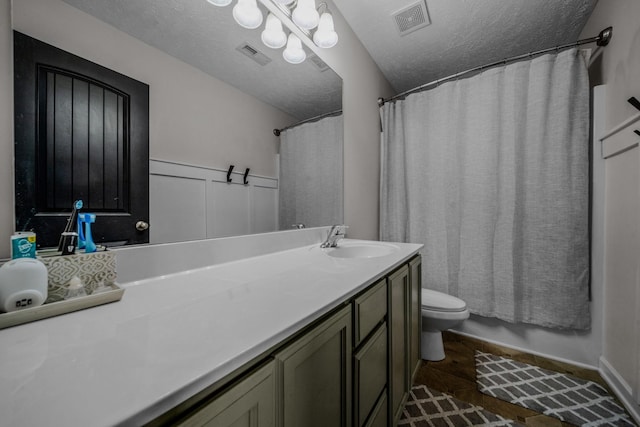 full bathroom featuring a textured ceiling, vanity, toilet, and shower / tub combo with curtain