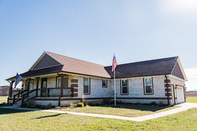 view of front of property featuring a porch, a garage, and a front lawn