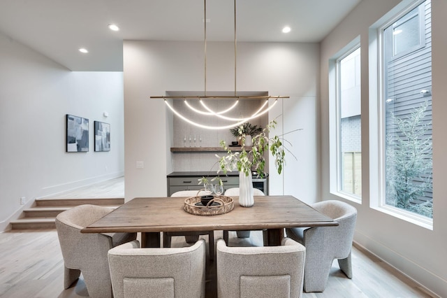 dining area with light hardwood / wood-style floors and a wealth of natural light