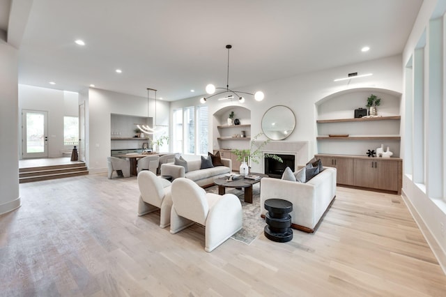 living room featuring built in shelves and light hardwood / wood-style floors