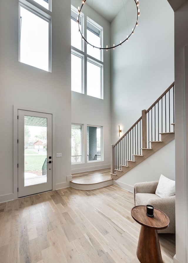 entryway featuring light hardwood / wood-style flooring and a towering ceiling