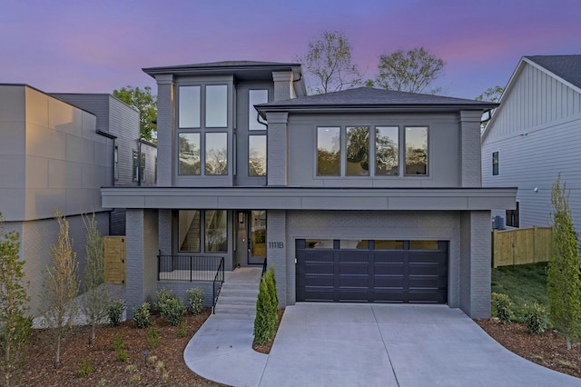 contemporary house featuring covered porch and a garage