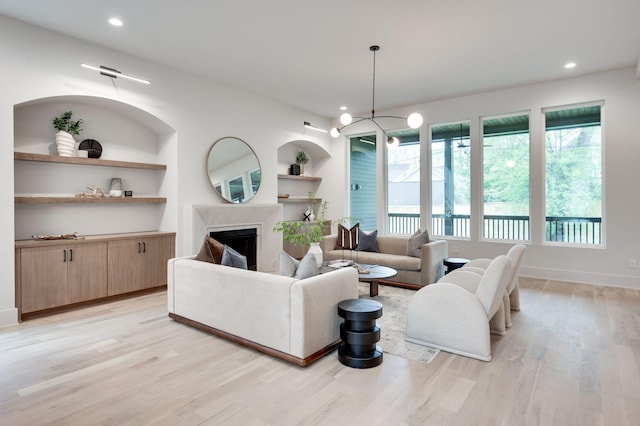 living room featuring built in features and light hardwood / wood-style floors