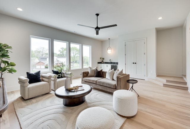 living room with ceiling fan and light hardwood / wood-style floors