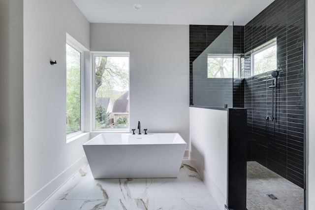 bathroom with a wealth of natural light and shower with separate bathtub