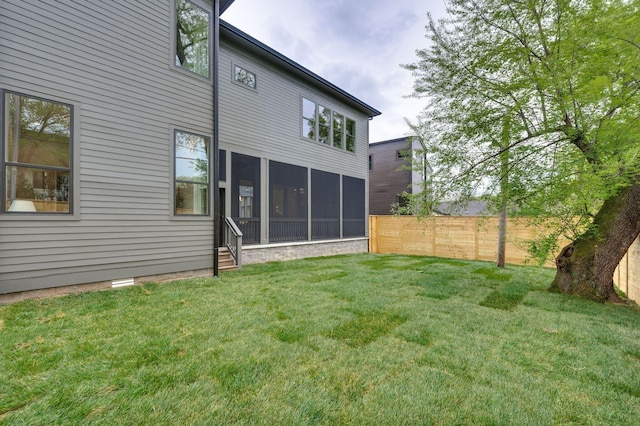 back of property with a lawn and a sunroom