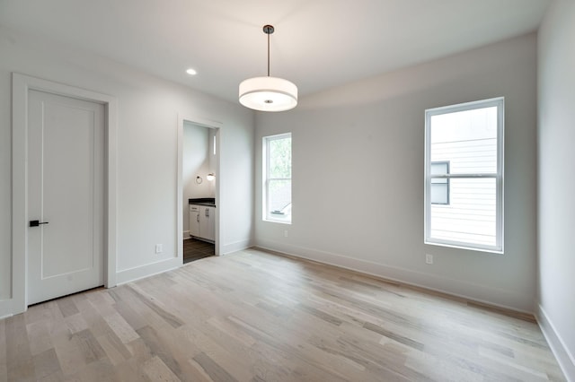 unfurnished bedroom featuring light wood-type flooring and connected bathroom