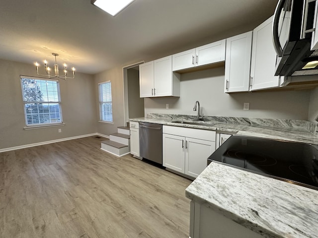 kitchen featuring stainless steel dishwasher, sink, decorative light fixtures, a notable chandelier, and white cabinets