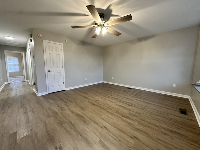 empty room with ceiling fan and dark wood-type flooring