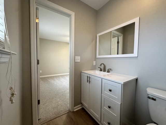 bathroom with hardwood / wood-style floors, vanity, and toilet