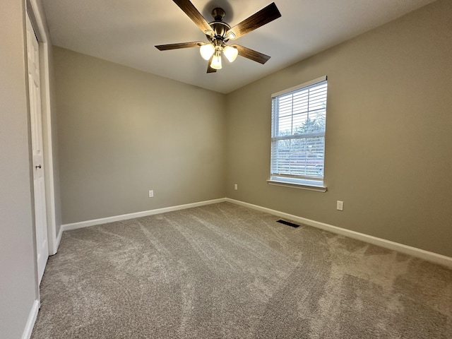 carpeted spare room with ceiling fan