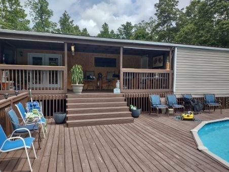 back of house featuring a swimming pool side deck