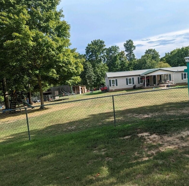 view of yard with a playground and a trampoline