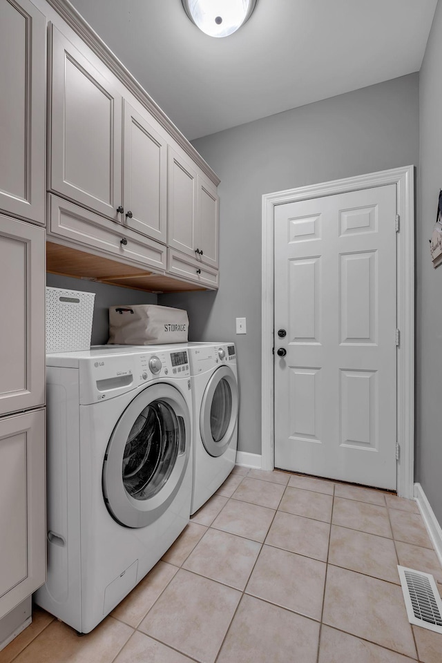 laundry area featuring light tile patterned floors, cabinets, and independent washer and dryer