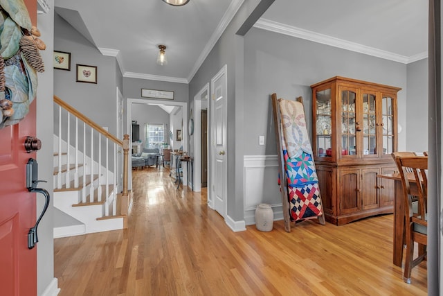 foyer featuring ornamental molding and light hardwood / wood-style flooring