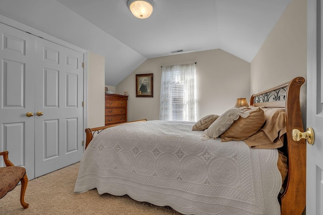 bedroom with light colored carpet, a closet, and lofted ceiling