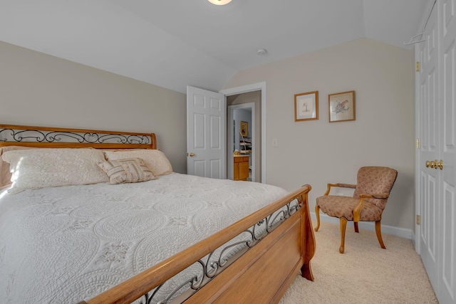 bedroom featuring light colored carpet and vaulted ceiling