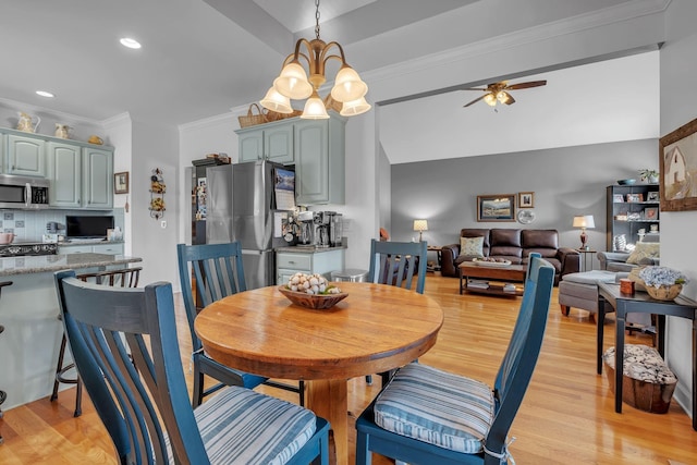 dining space featuring light wood-type flooring, ceiling fan with notable chandelier, and ornamental molding