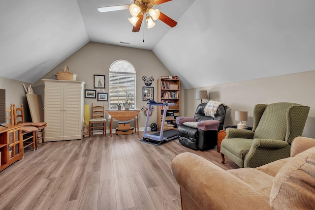 living room with ceiling fan, vaulted ceiling, and light wood-type flooring