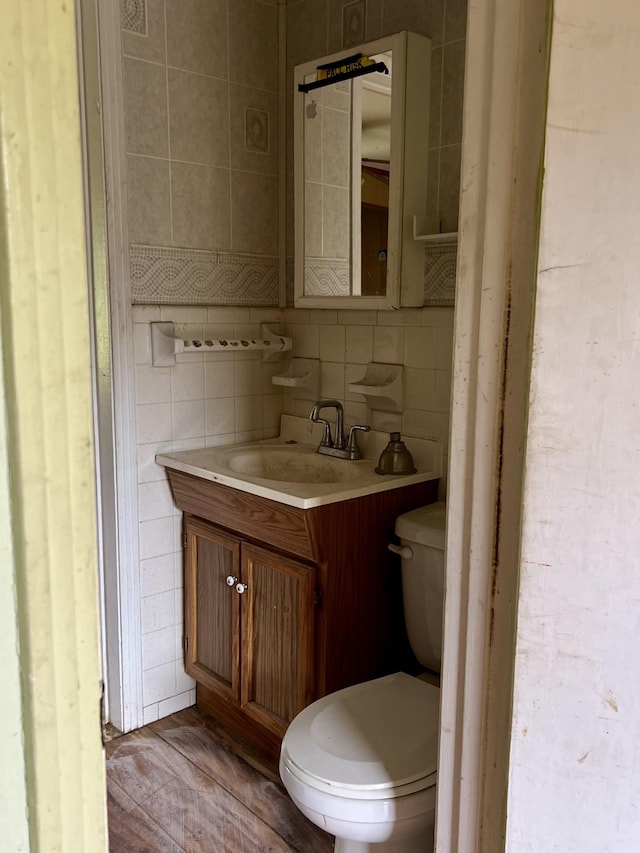 bathroom with vanity, tasteful backsplash, toilet, and tile walls