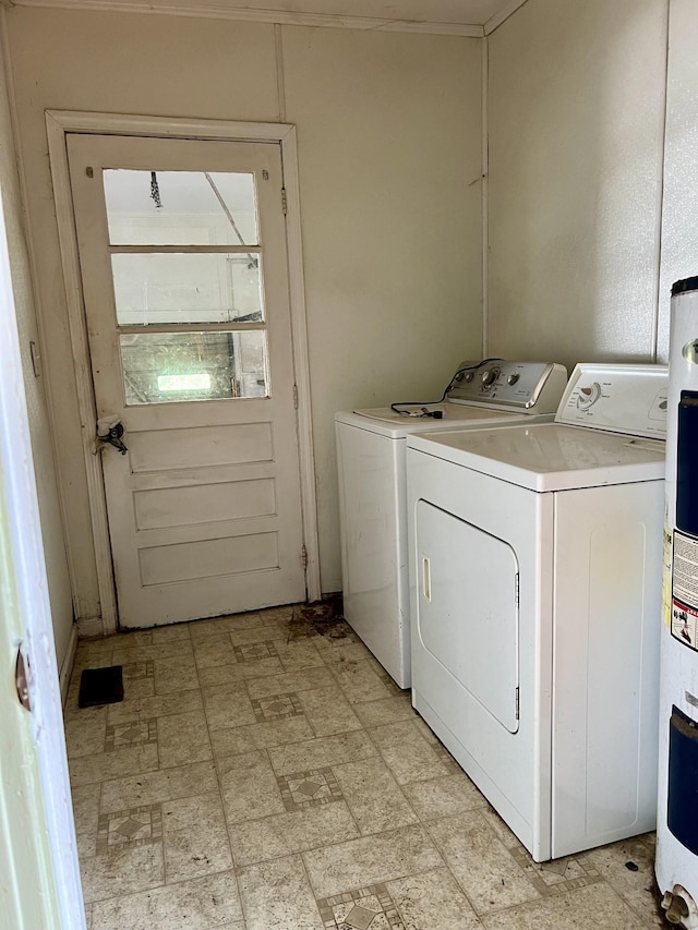 clothes washing area featuring water heater and washing machine and clothes dryer