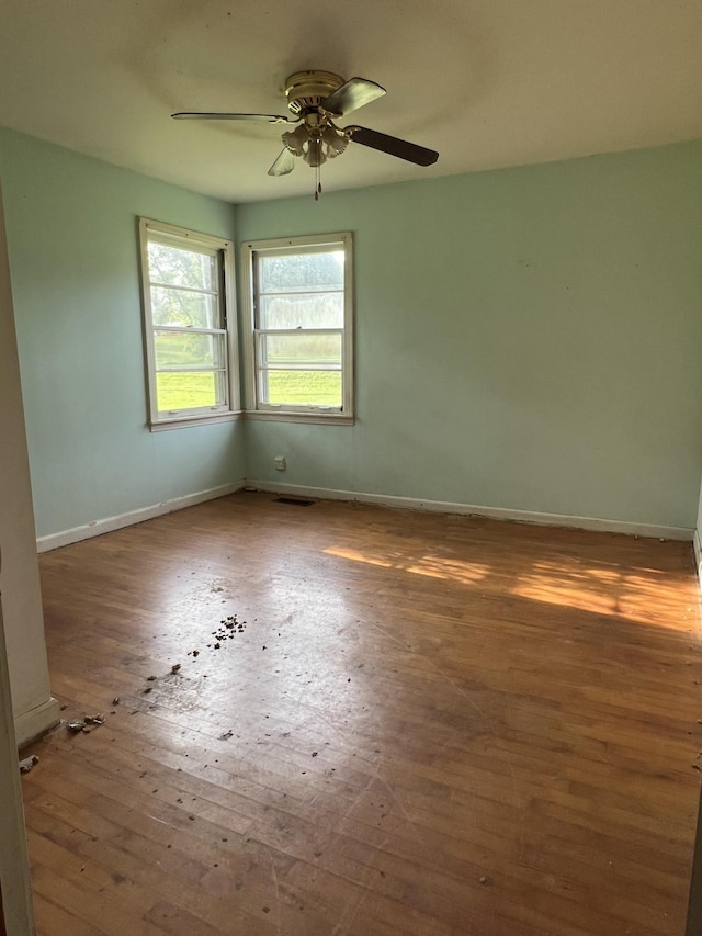 empty room with ceiling fan and hardwood / wood-style flooring