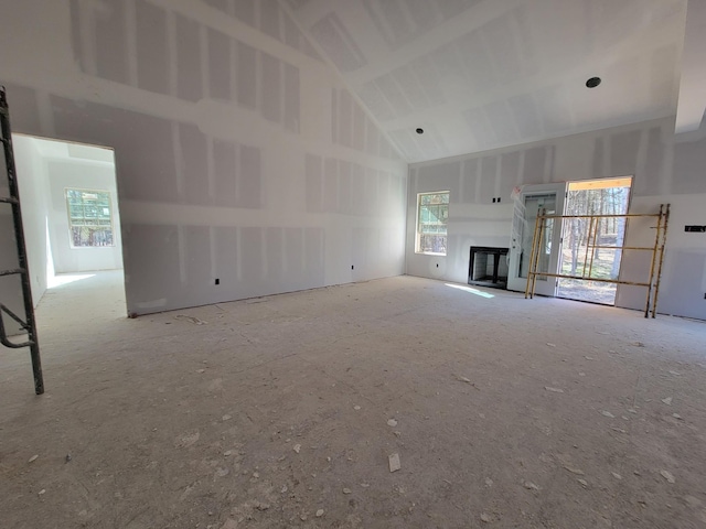 unfurnished living room featuring high vaulted ceiling