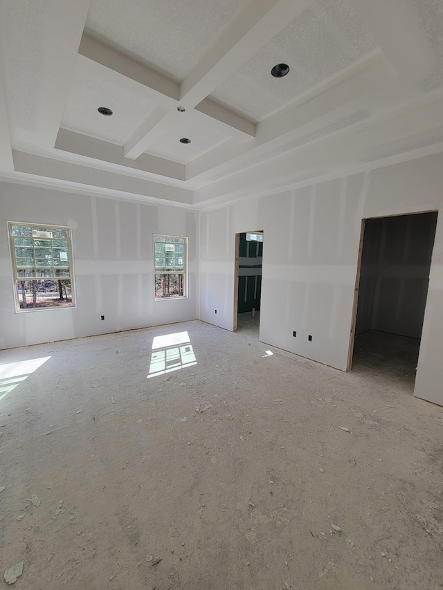 empty room with coffered ceiling and beamed ceiling