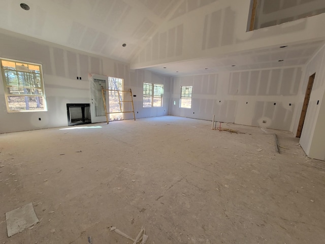 unfurnished living room with high vaulted ceiling