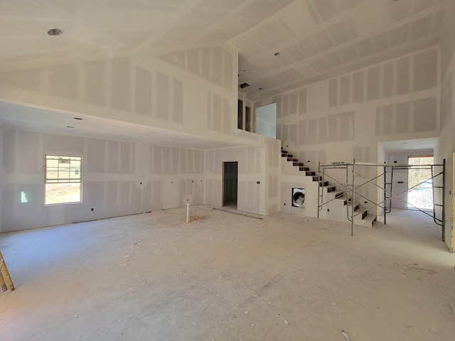 unfurnished living room with high vaulted ceiling