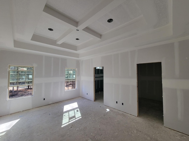 spare room featuring beamed ceiling, plenty of natural light, and coffered ceiling