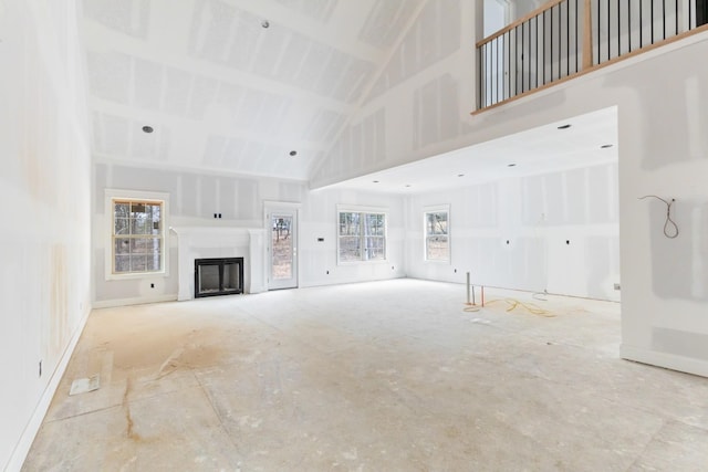 unfurnished living room with high vaulted ceiling