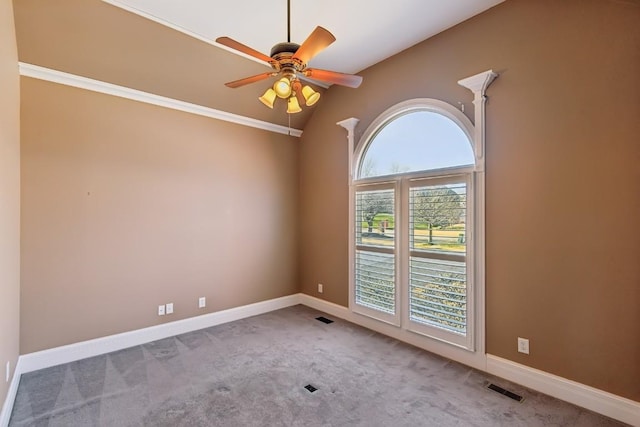 empty room with ceiling fan, crown molding, light carpet, and vaulted ceiling