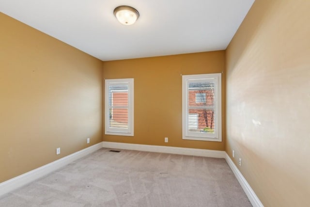 carpeted spare room featuring plenty of natural light