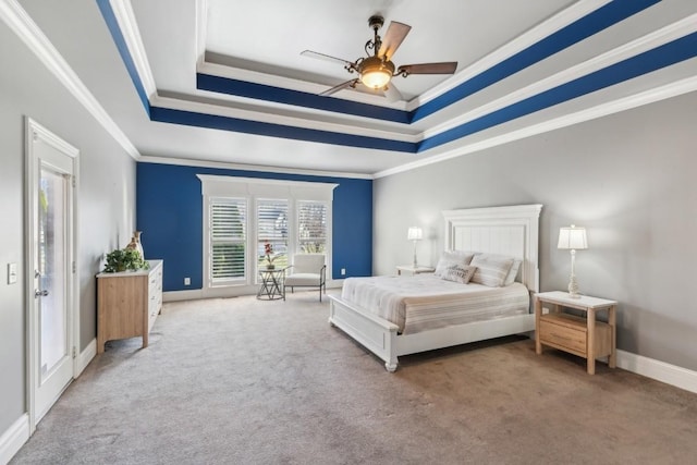 bedroom with carpet, a tray ceiling, ceiling fan, and crown molding