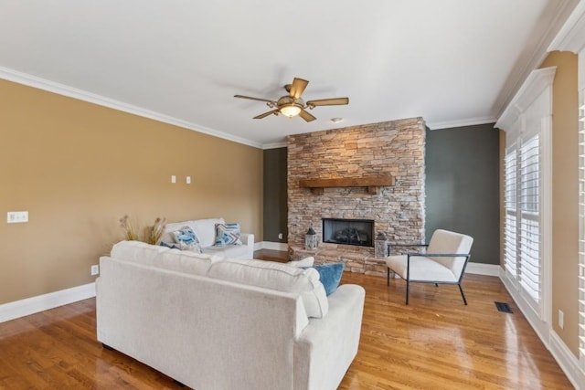 living room with a fireplace, light wood-type flooring, ceiling fan, and ornamental molding