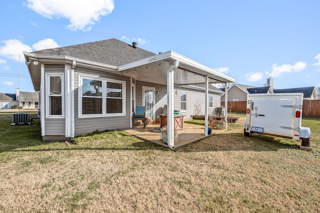 rear view of house with a yard, a patio, and central AC