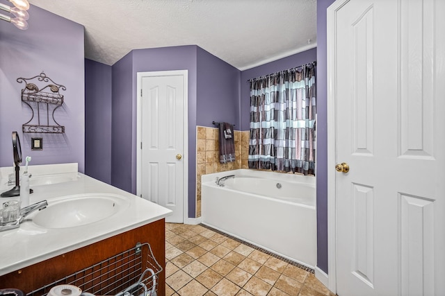 bathroom with tile patterned floors, a washtub, a textured ceiling, and vanity