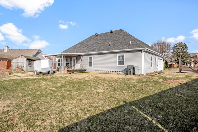 back of house featuring a lawn and a storage shed