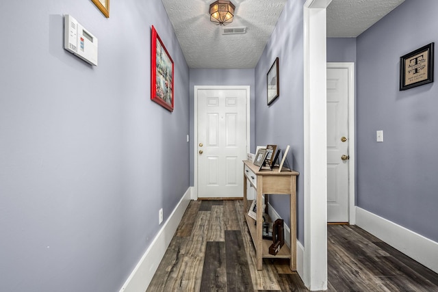 doorway featuring dark hardwood / wood-style floors and a textured ceiling