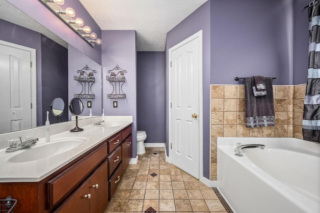 bathroom with vanity, a bath, tile patterned flooring, toilet, and a textured ceiling