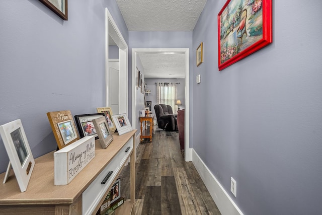 hall with dark hardwood / wood-style flooring and a textured ceiling